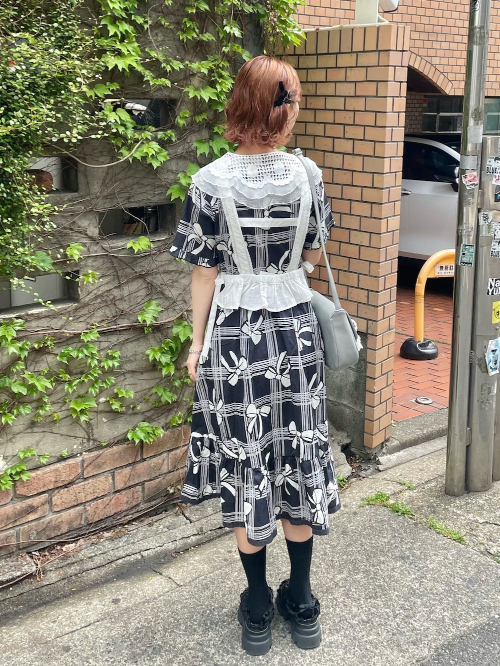 ブラック系のサンダル、ホワイト系のシャツ/ブラウス、ブルー系のショルダーバッグを着用したレディースの春コーディネートの4枚目の写真