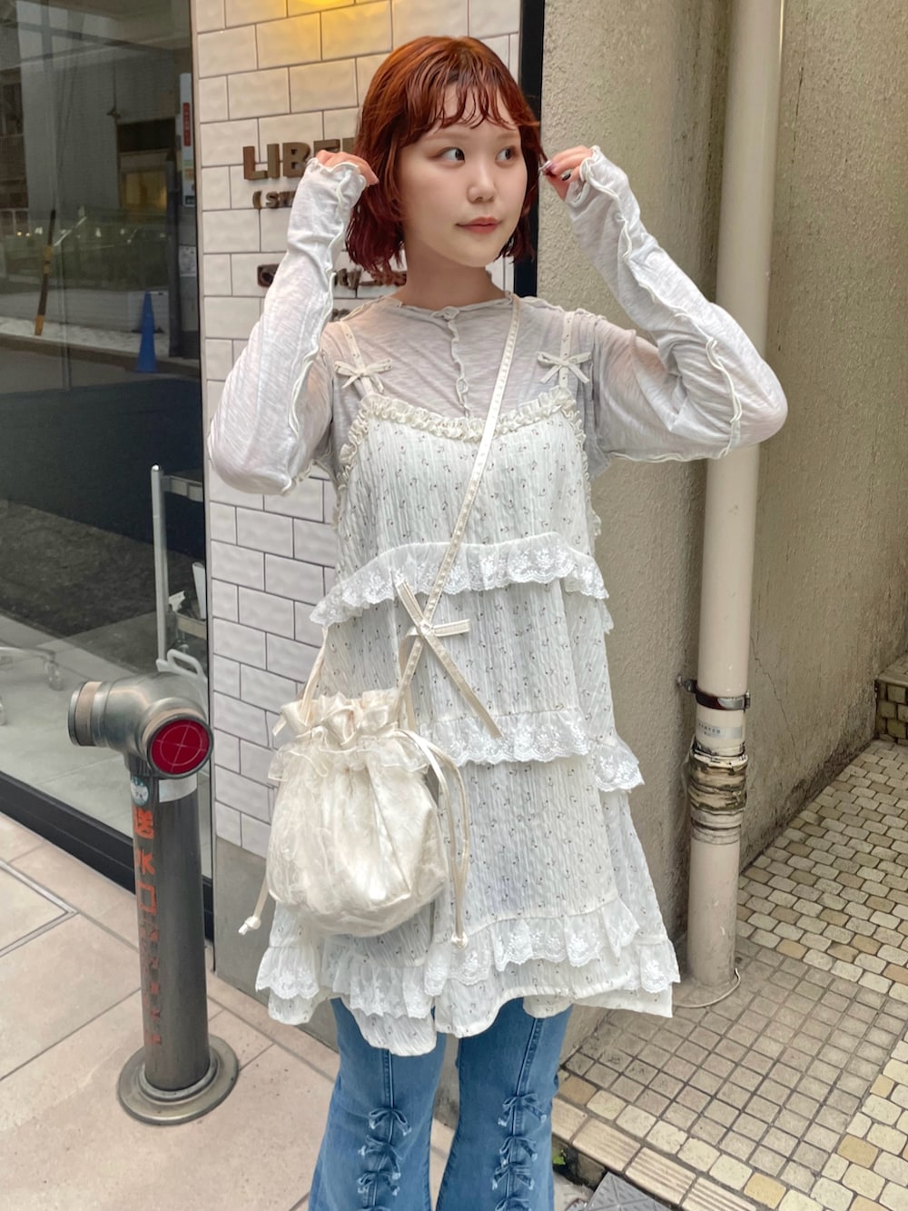 ブルー系のデニムパンツ、グレー系のTシャツ/カットソー、ホワイト系のサンダルを着用したレディースの夏コーディネートの6枚目の写真