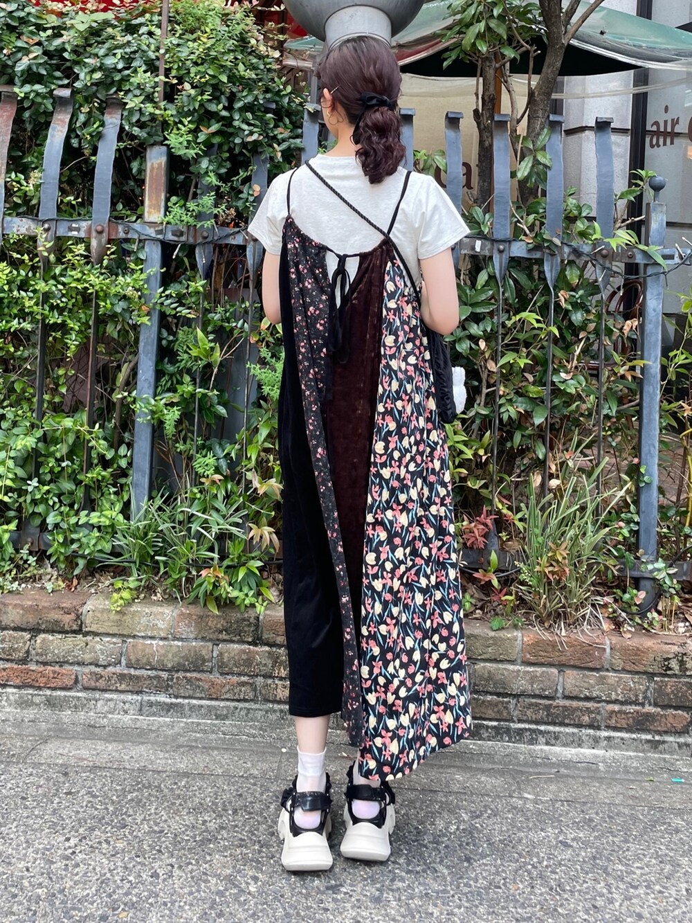 ブラック系のワンピース、グレー系のTシャツ/カットソー、ブラック系のサンダルを着用したレディースの夏コーディネートの3枚目の写真