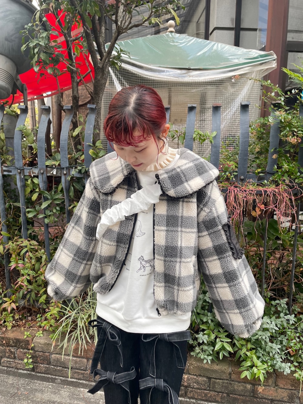 ブラック系のデニムパンツ、ホワイト系のスニーカー、ホワイト系のスウェットを着用したレディースの冬コーディネートの3枚目の写真