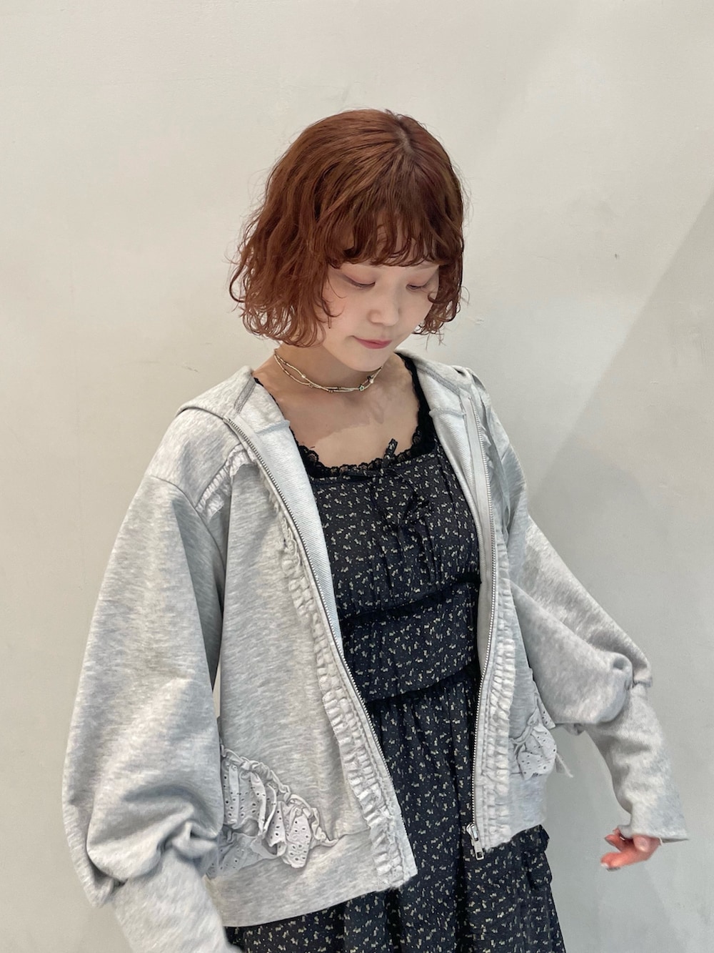 グレー系のパーカー、グレー系のメッセンジャーバッグ、ブラック系のワンピースを着用したレディースの冬コーディネートの5枚目の写真