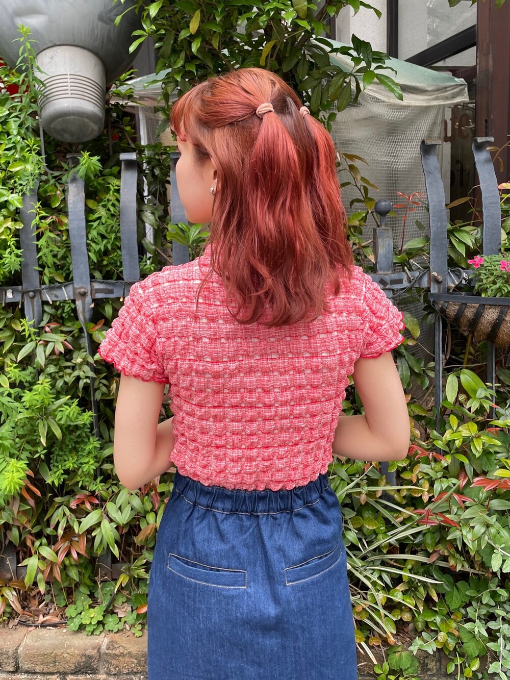 ブルー系のデニムスカート、レッド系のTシャツ/カットソー、ブラック系のサンダルを着用したレディースの春コーディネートの5枚目の写真