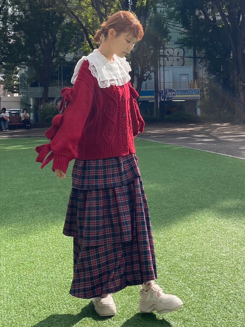 レッド系のカーディガン/ボレロ、ホワイト系のシャツ/ブラウス、ブルー系のスカートを着用したレディースの秋コーディネートの2枚目の写真