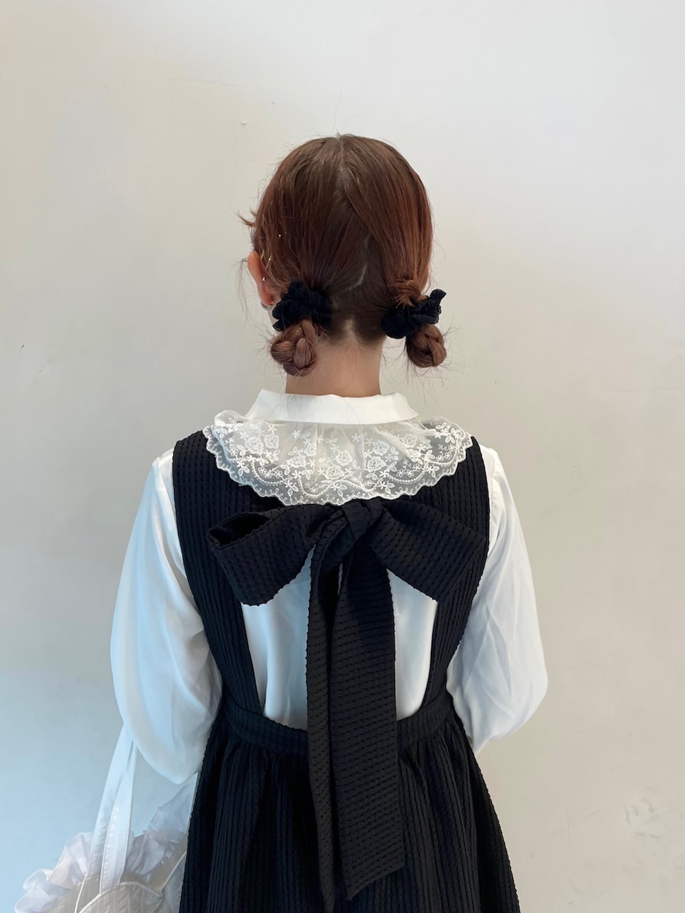 ブラック系のワンピース、ホワイト系のトートバッグ、ブラック系のスニーカーを着用したレディースの春コーディネートの6枚目の写真