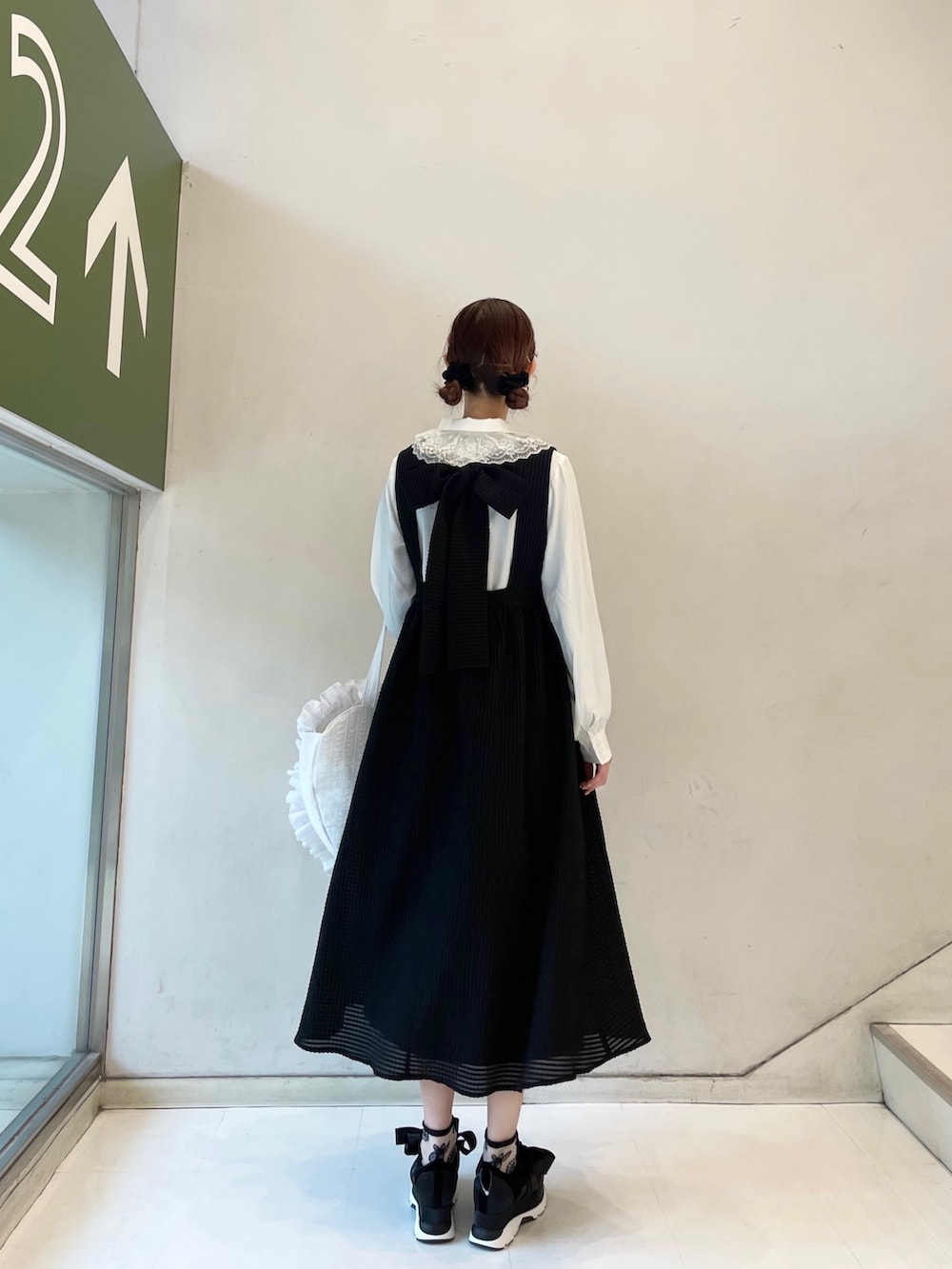 ブラック系のワンピース、ホワイト系のトートバッグ、ブラック系のスニーカーを着用したレディースの春コーディネートの4枚目の写真