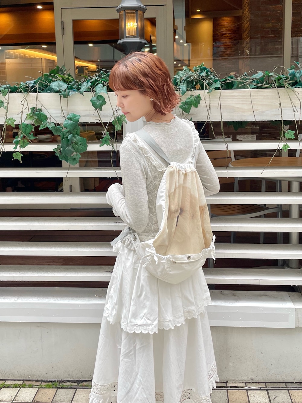 ホワイト系のスカート、ホワイト系のバレエシューズ、グレー系のTシャツ/カットソーを着用したレディースの冬コーディネートの6枚目の写真