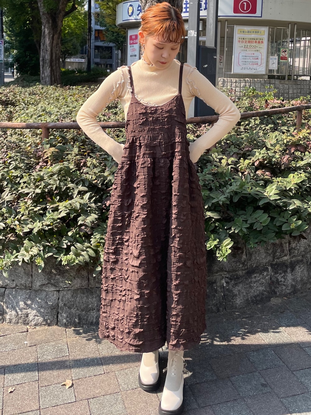 ブラウン系のワンピース、ホワイト系のブルゾン、イエロー系のニット/セーターを着用したレディースの秋コーディネートの4枚目の写真