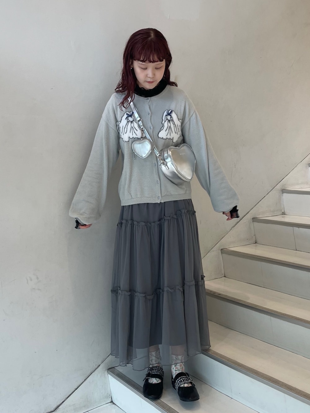 グレー系のワンピース、シルバー系のショルダーバッグ、グレー系のカーディガン/ボレロを着用したレディースの夏コーディネートの2枚目の写真
