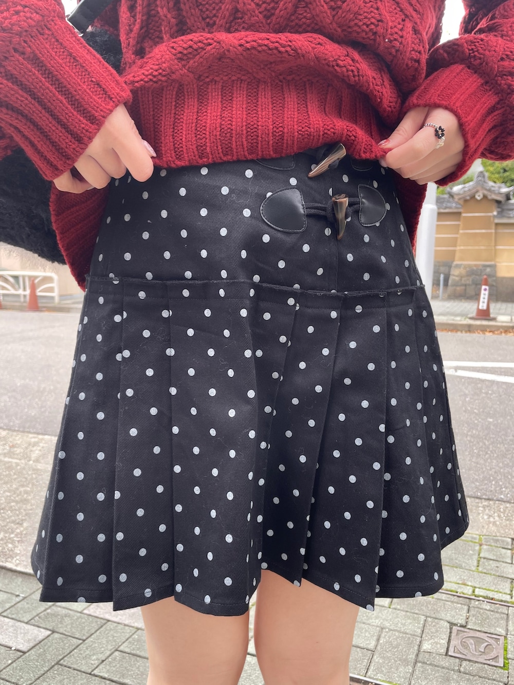 ブラック系のローファー、レッド系のニット/セーター、ブラック系のスカートを着用したレディースの秋コーディネートの4枚目の写真