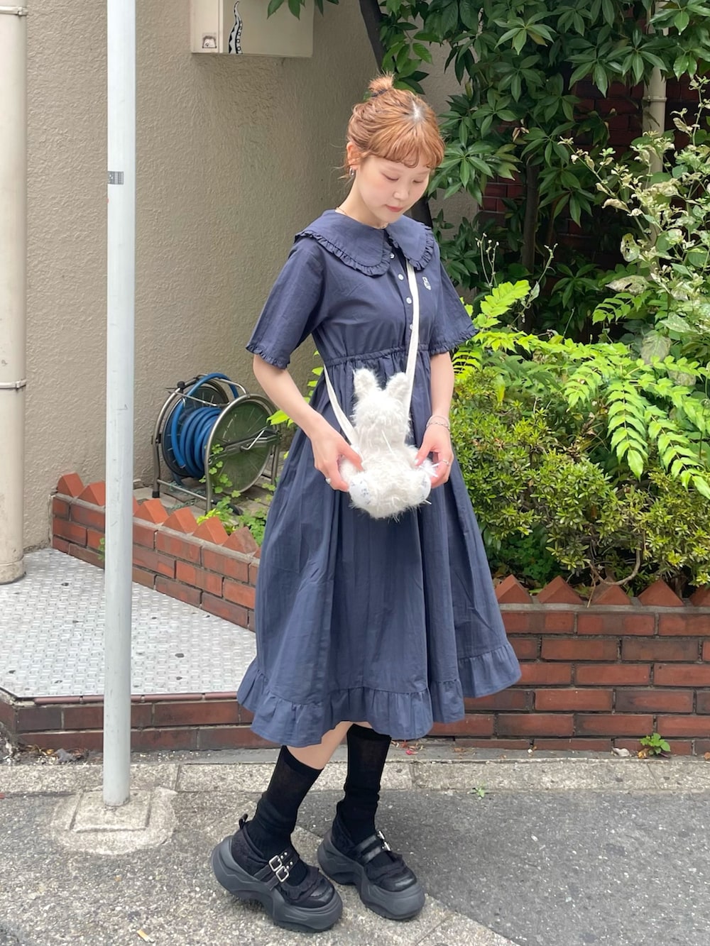 ブルー系のワンピース、ブラック系のスニーカー、ホワイト系のショルダーバッグを着用したレディースの夏コーディネートの2枚目の写真