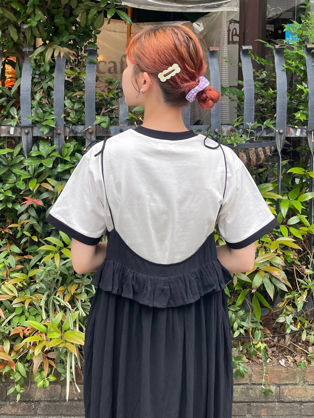 ブラック系のスカート、ホワイト系のTシャツ/カットソー、グレー系のサンダルを着用したレディースの春コーディネートの5枚目の写真