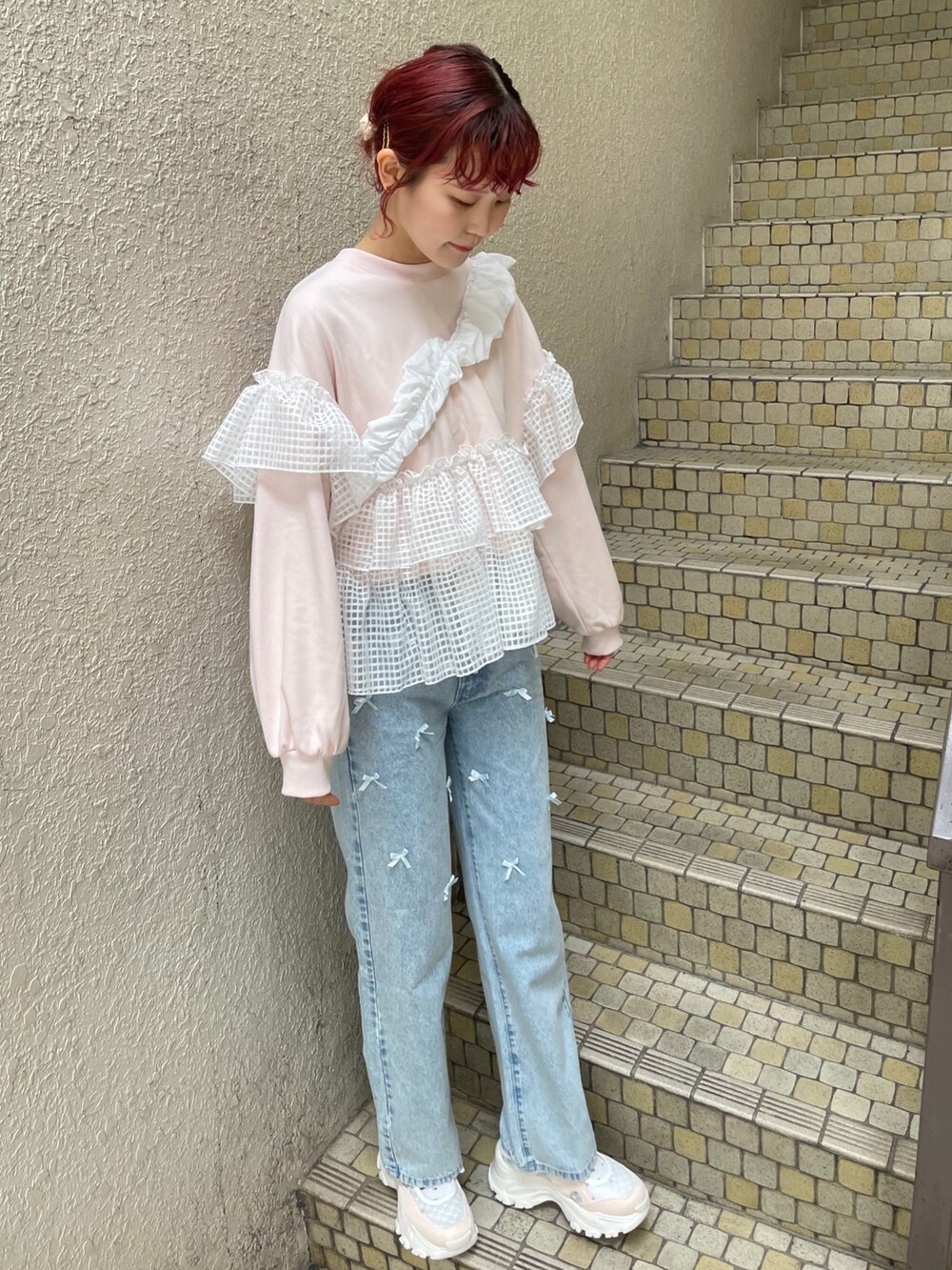 ブルー系のデニムパンツ、ピンク系のスウェット、ホワイト系のショルダーバッグを着用したレディースの冬コーディネートの2枚目の写真