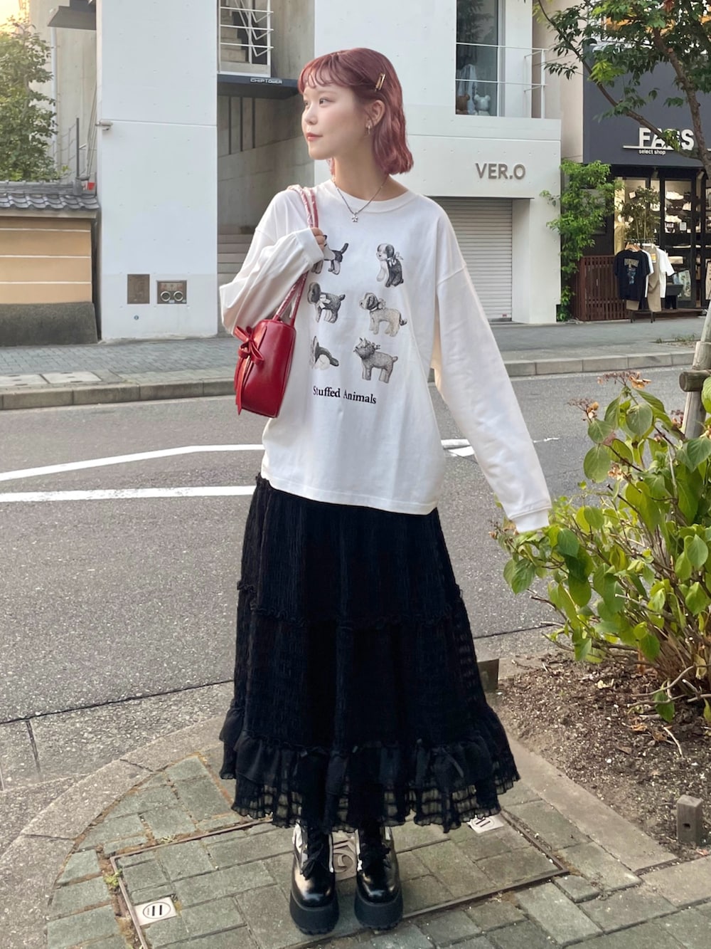 ホワイト系のTシャツ/カットソー、ブラック系のスカート、ブラック系のブーツを着用したレディースの夏コーディネートの3枚目の写真