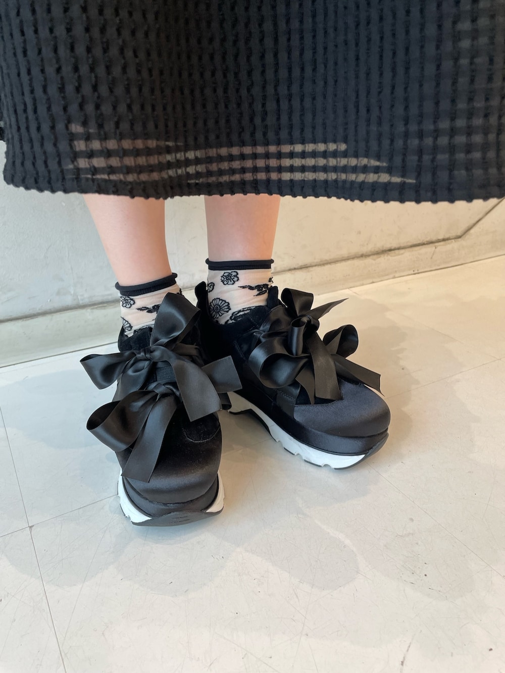 ブラック系のワンピース、ホワイト系のトートバッグ、ブラック系のスニーカーを着用したレディースの春コーディネートの7枚目の写真