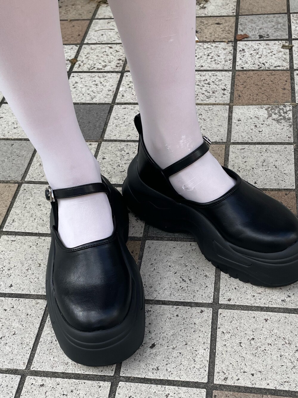 ブラック系のワンピース、ブラック系のスニーカーを着用したレディースの秋コーディネートの6枚目の写真