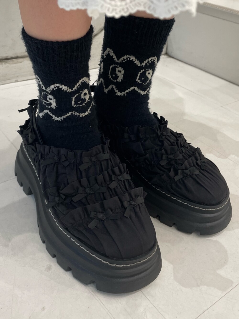 ブルー系のニット/セーター、グレー系のスカート、ホワイト系のショルダーバッグを着用したレディースの秋コーディネートの9枚目の写真