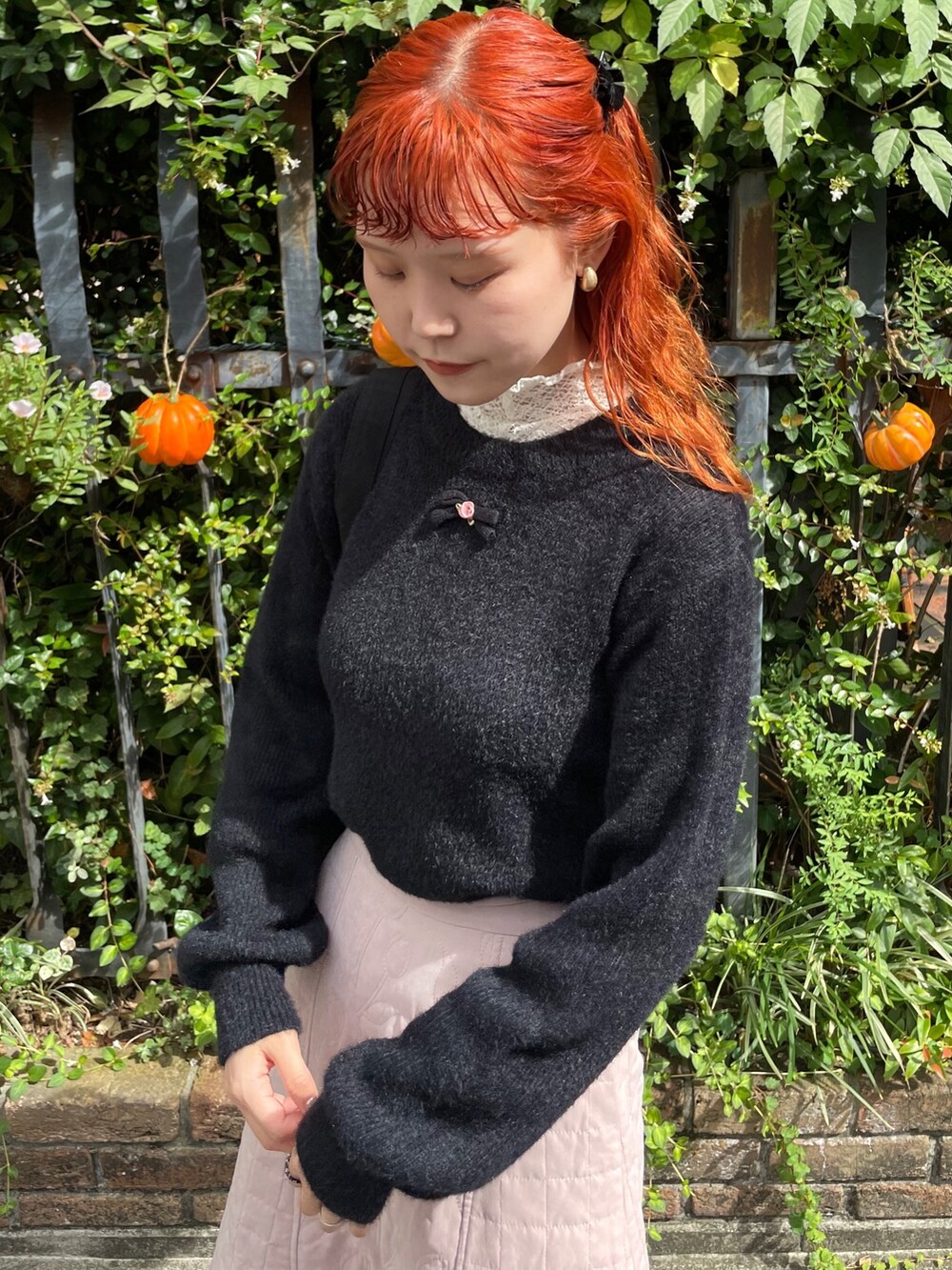 ピンク系のスカート、ブラック系のパンプス、ブラック系のトートバッグを着用したレディースの秋コーディネートの4枚目の写真