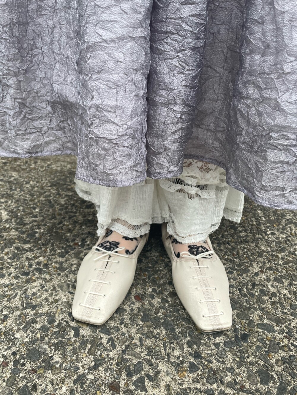 ホワイト系のニット/セーター、グレー系のワンピース、ホワイト系のスラックスを着用したレディースの春コーディネートの6枚目の写真