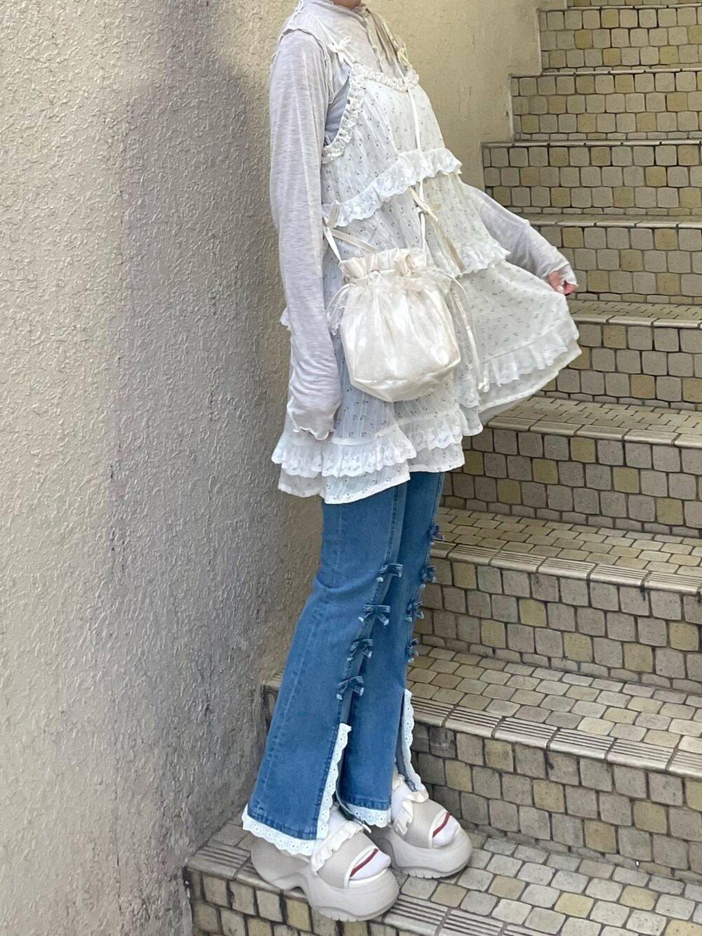 ブルー系のデニムパンツ、グレー系のTシャツ/カットソー、ホワイト系のサンダルを着用したレディースの夏コーディネートの4枚目の写真