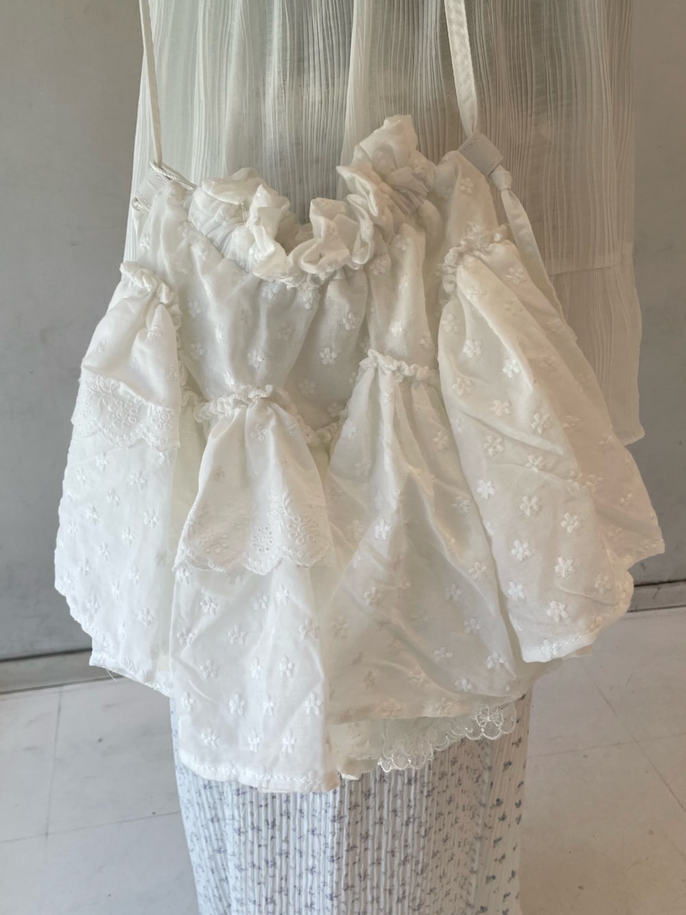 グリーン系のTシャツ/カットソー、ホワイト系のチュニック、ブルー系のスニーカーを着用したレディースの春コーディネートの7枚目の写真