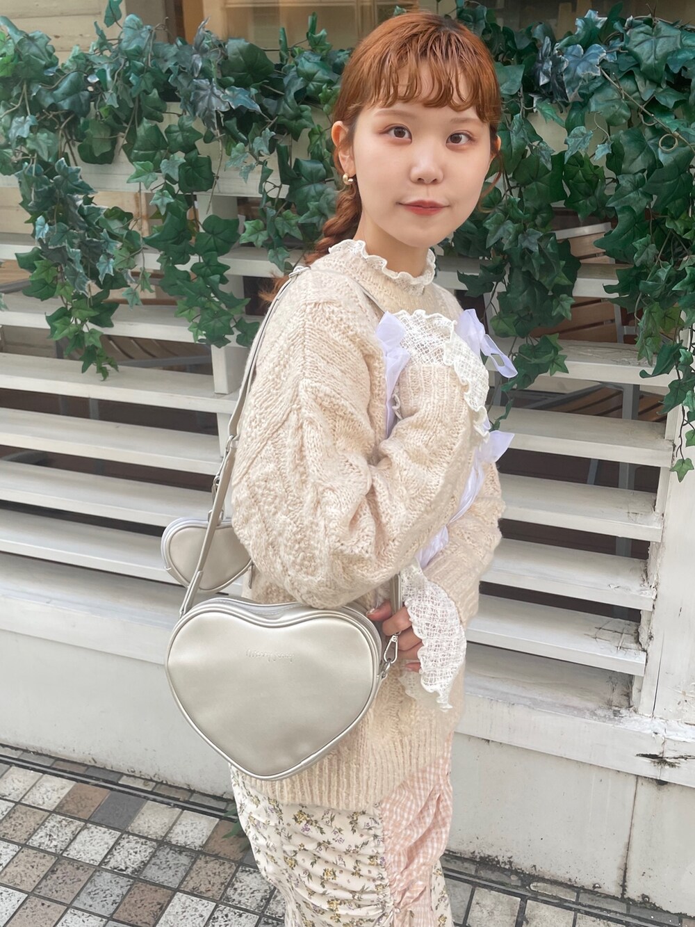 ホワイト系のスカート、ホワイト系のニット/セーター、シルバー系のハンドバッグを着用したレディースの秋コーディネートの4枚目の写真