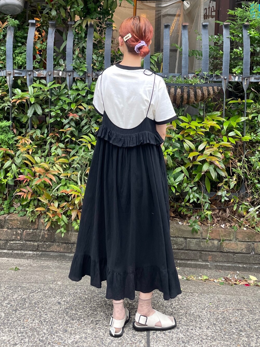 ブラック系のスカート、ホワイト系のTシャツ/カットソー、グレー系のサンダルを着用したレディースの春コーディネートの3枚目の写真