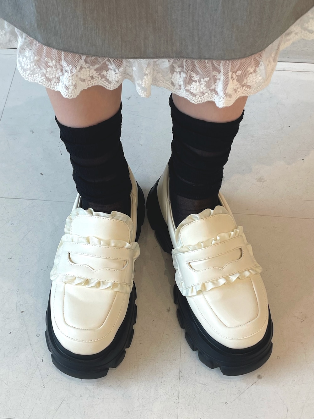 ピンク系のニット/セーター、グレー系のスカート、ホワイト系のショルダーバッグを着用したレディースの秋コーディネートの7枚目の写真