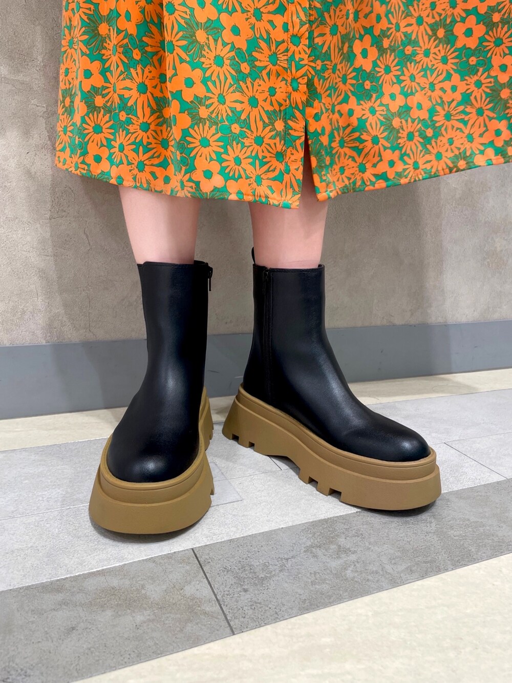 ブラック系のブーツ、グリーン系のワンピース、ホワイト系のトートバッグを着用したレディースの冬コーディネートの5枚目の写真