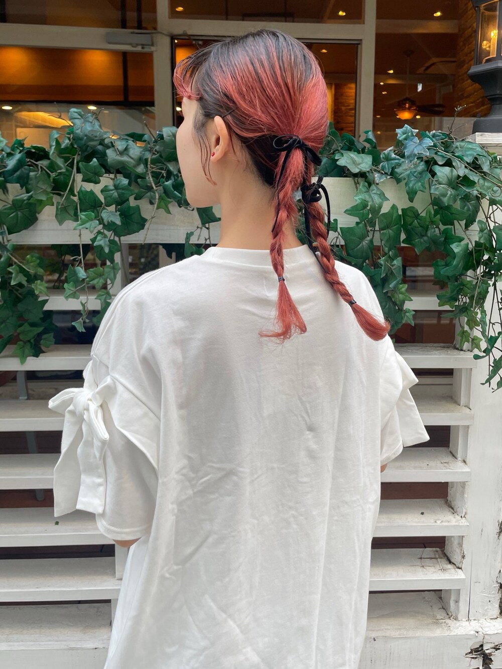 ホワイト系のTシャツ/カットソー、ホワイト系のスカート、ブラック系のスニーカーを着用したレディースの春コーディネートの4枚目の写真