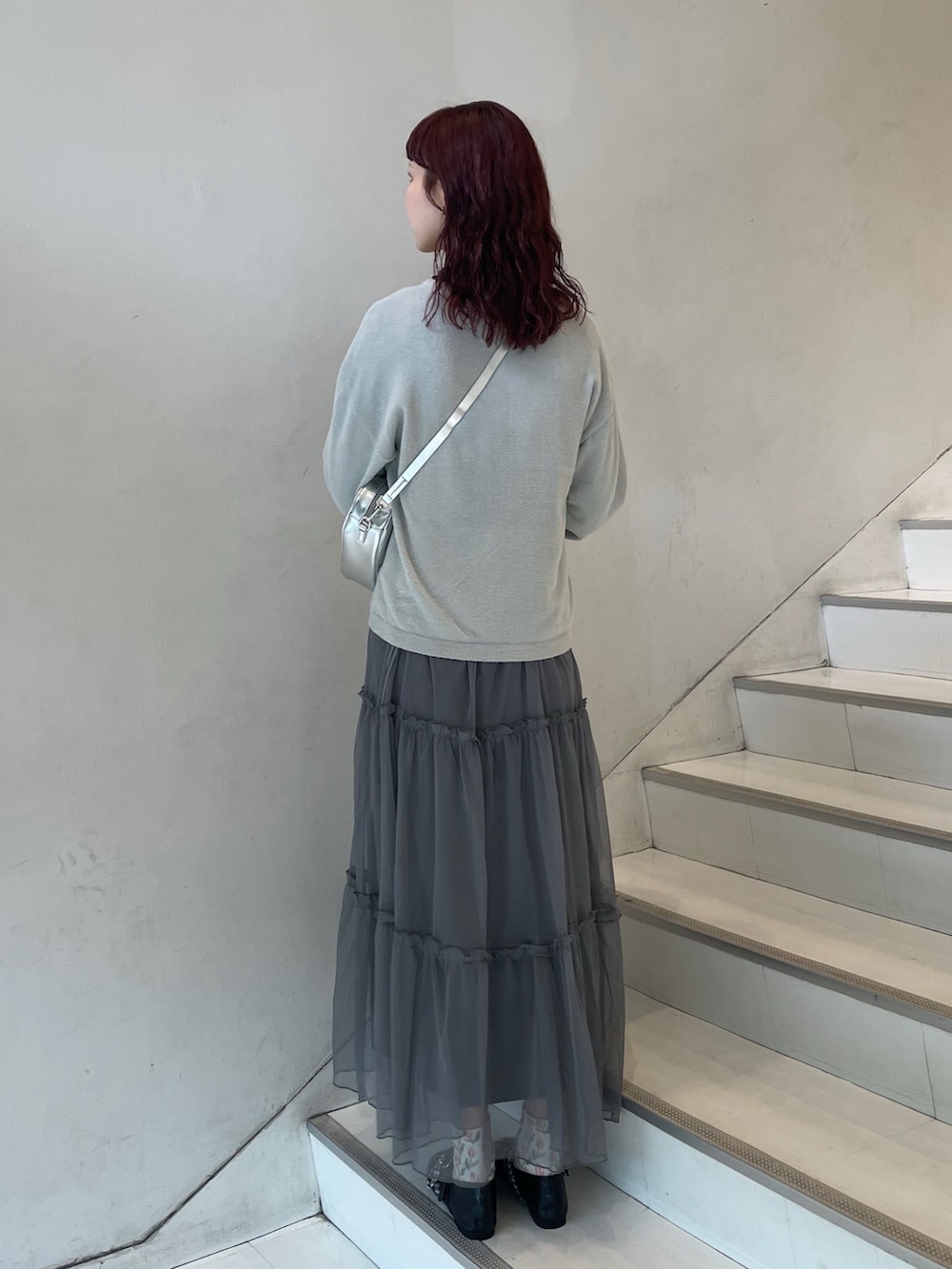 グレー系のワンピース、シルバー系のショルダーバッグ、グレー系のカーディガン/ボレロを着用したレディースの夏コーディネートの3枚目の写真