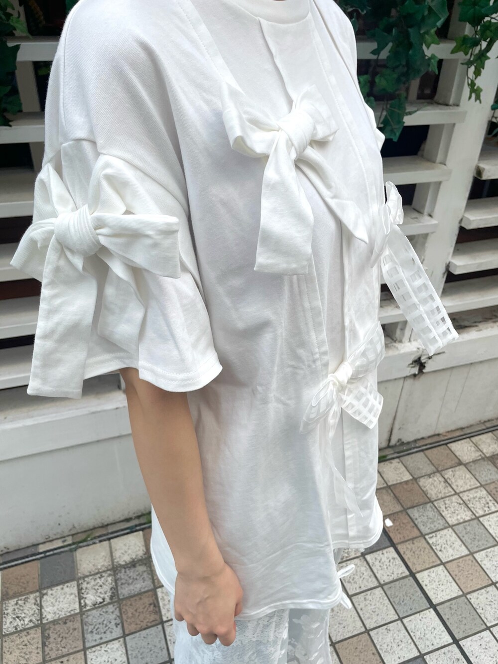 ホワイト系のTシャツ/カットソー、ホワイト系のスカート、ブラック系のスニーカーを着用したレディースの春コーディネートの5枚目の写真