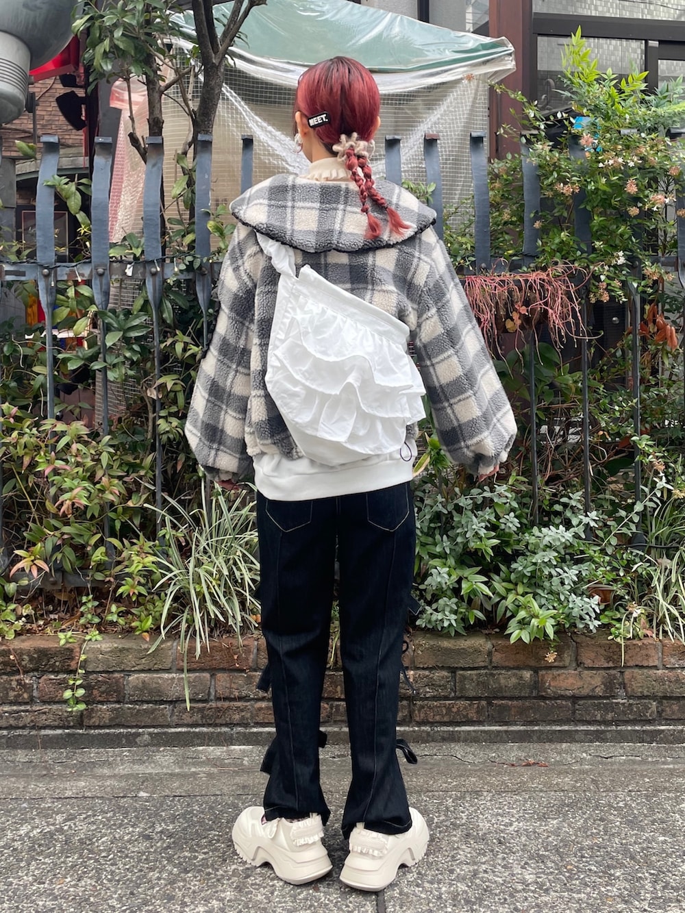 ブラック系のデニムパンツ、ホワイト系のスニーカー、ホワイト系のスウェットを着用したレディースの冬コーディネートの2枚目の写真