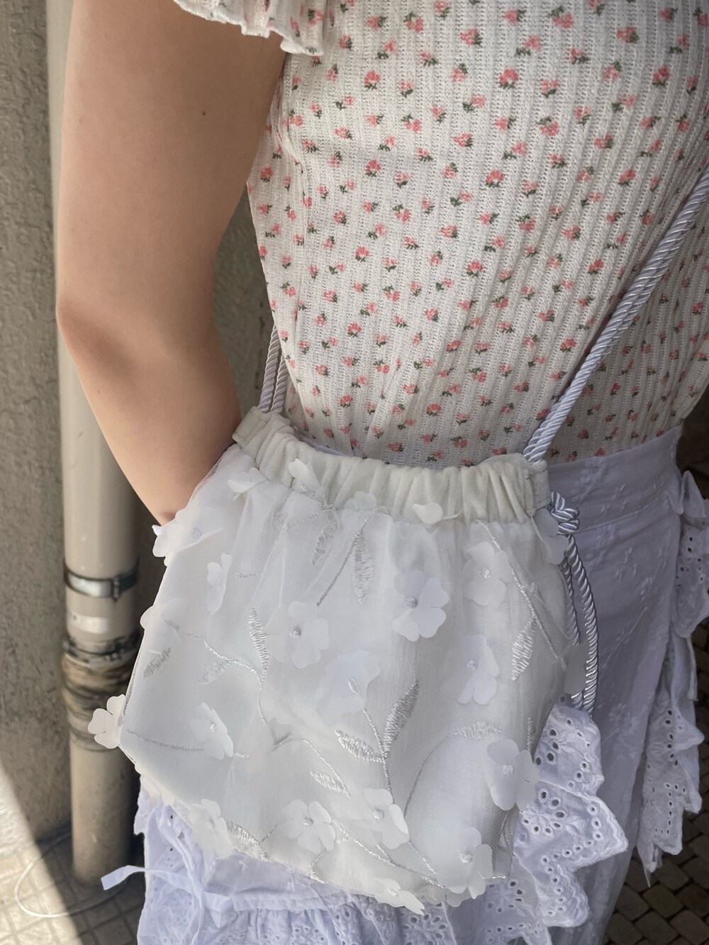 ホワイト系のショルダーバッグ、ホワイト系のスカート、ピンク系のTシャツ/カットソーを着用したレディースの春コーディネートの7枚目の写真