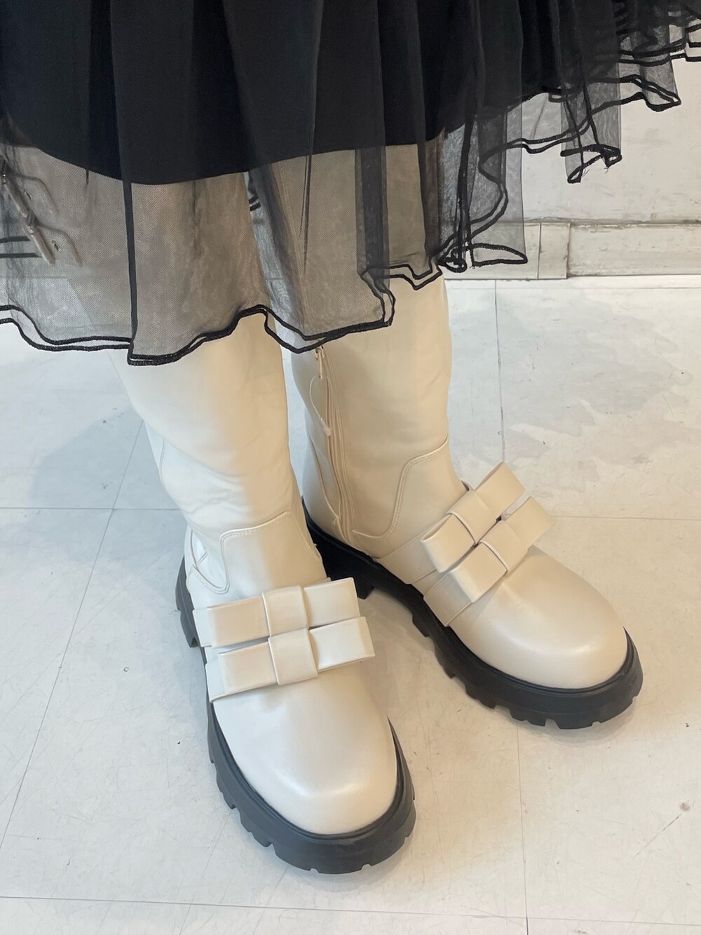 ブラック系のスカート、ホワイト系のシャツ/ブラウス、レッド系のニット/セーターを着用したレディースの冬コーディネートの9枚目の写真