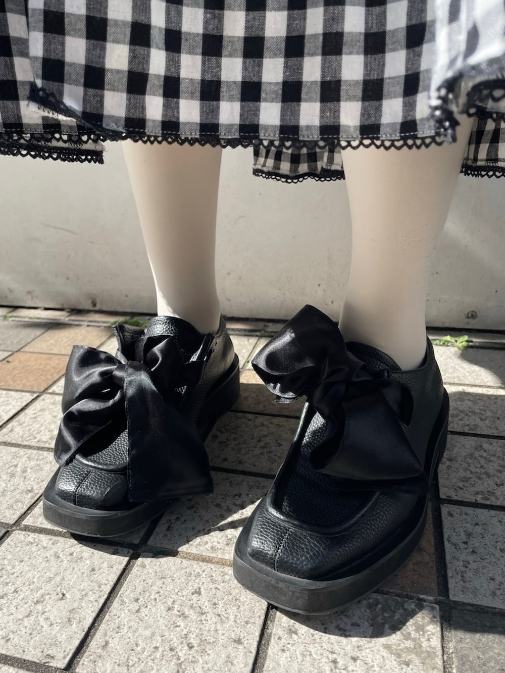 ホワイト系のニット/セーター、ブラック系のスカート、ブラック系のモカシン/デッキシューズを着用したレディースの冬コーディネートの4枚目の写真