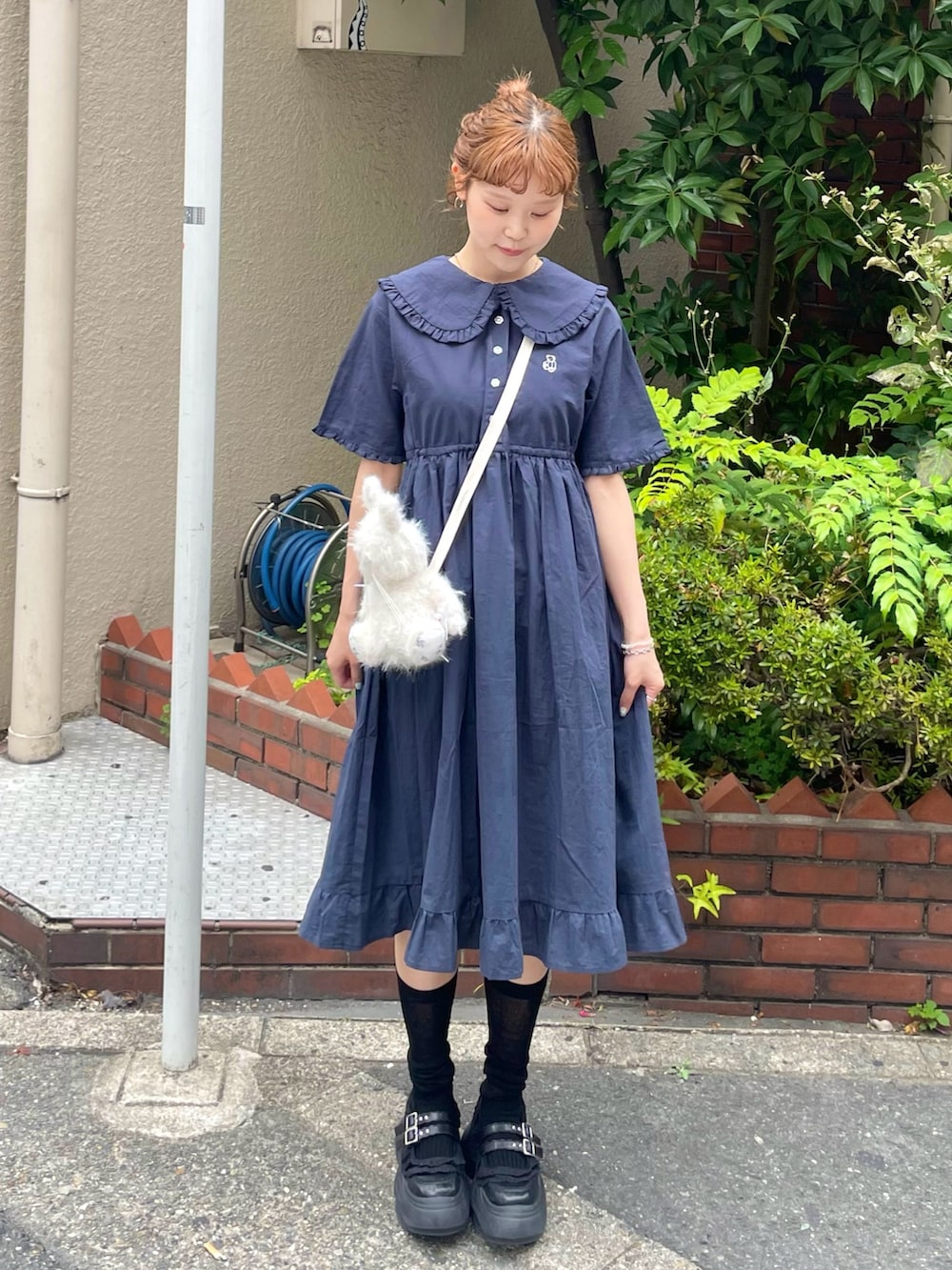 ブルー系のワンピース、ブラック系のスニーカー、ホワイト系のショルダーバッグを着用したレディースの夏コーディネートの4枚目の写真