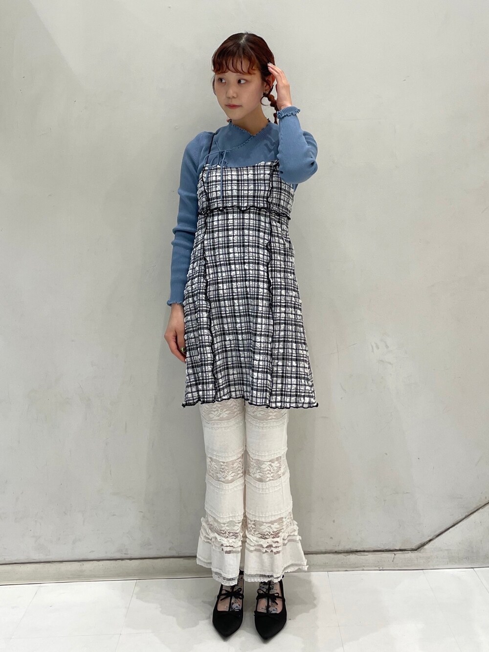 ホワイト系のスラックス、ブルー系のニット/セーター、ブラック系のワンピースを着用したレディースの冬コーディネートの2枚目の写真