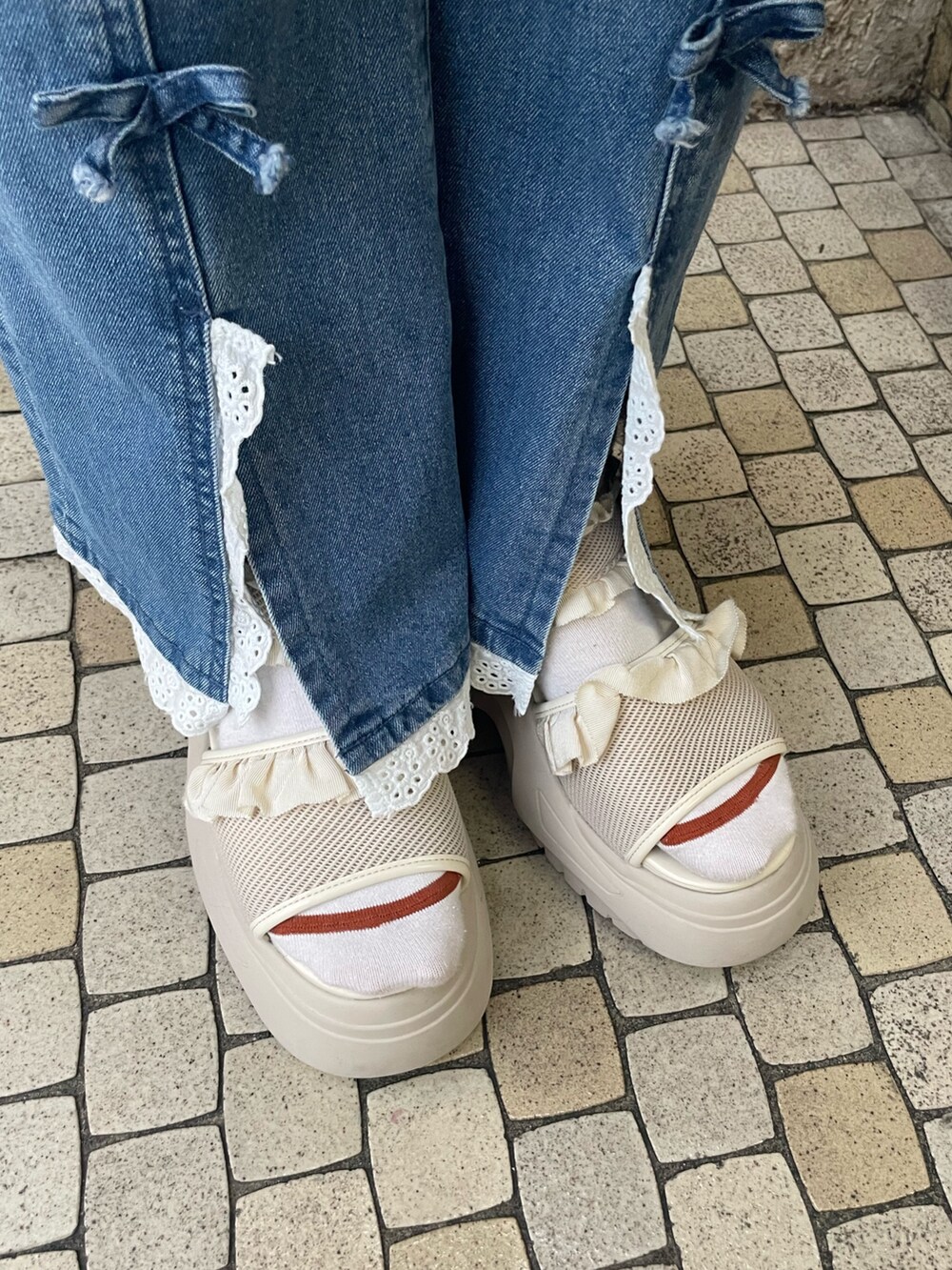 ブルー系のデニムパンツ、グレー系のTシャツ/カットソー、ホワイト系のサンダルを着用したレディースの夏コーディネートの8枚目の写真