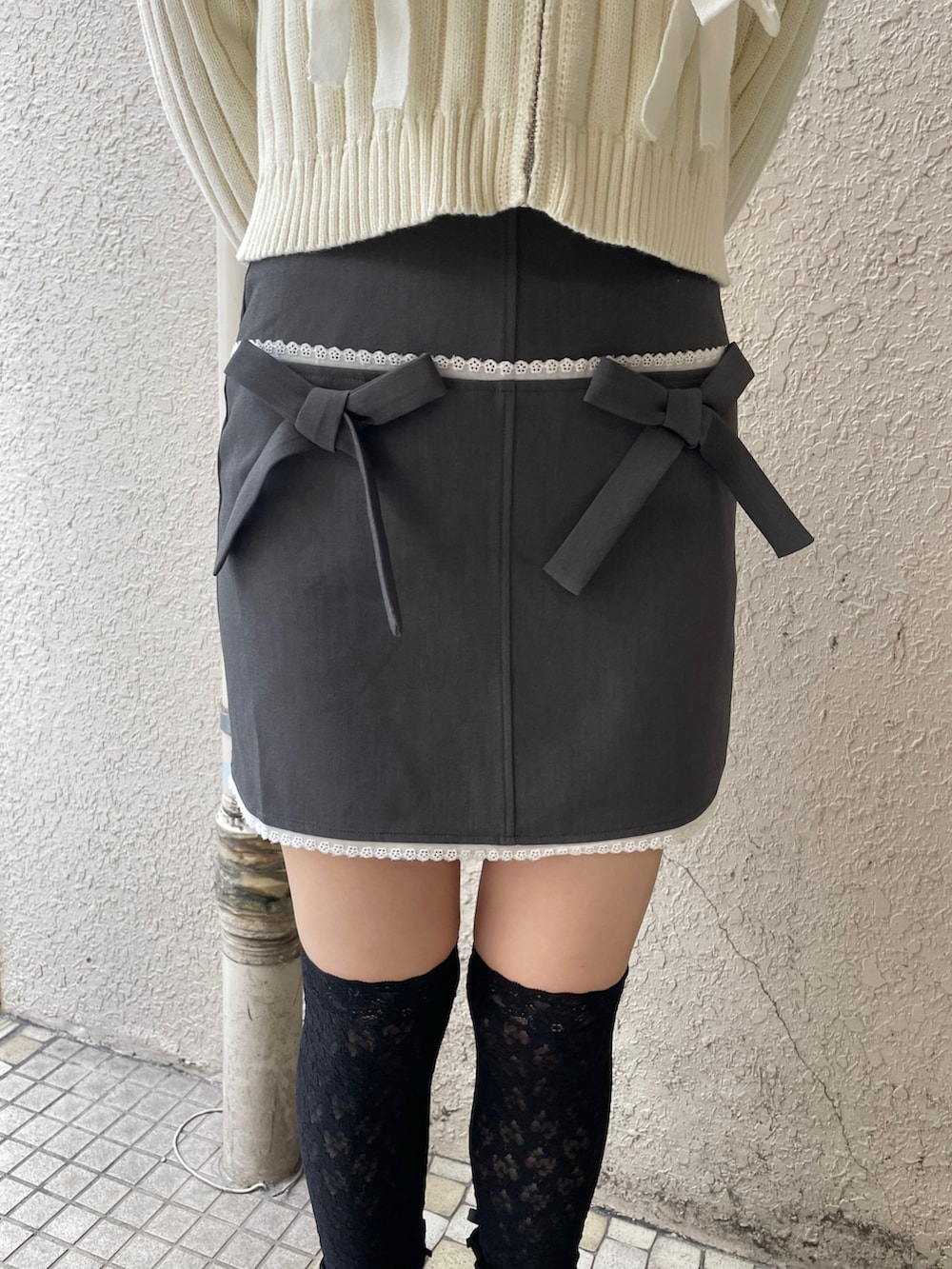 ホワイト系のカーディガン/ボレロ、グレー系のスカート、グレー系のショルダーバッグを着用したレディースの秋コーディネートの6枚目の写真