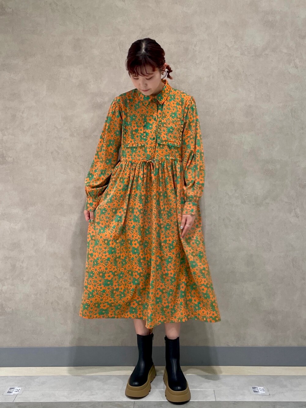 ブラック系のブーツ、グリーン系のワンピース、ホワイト系のトートバッグを着用したレディースの冬コーディネートの3枚目の写真