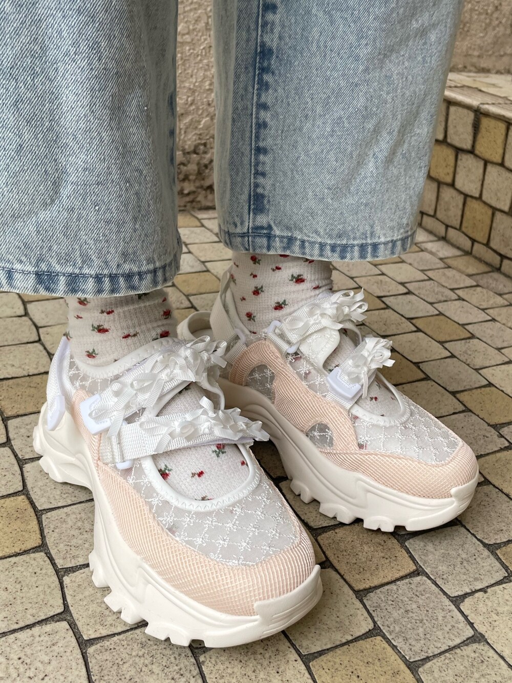 ブルー系のデニムパンツ、ピンク系のスウェット、ホワイト系のショルダーバッグを着用したレディースの冬コーディネートの8枚目の写真