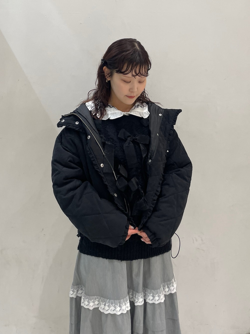 グレー系のスカート、ブラック系のダウンジャケット/コート、ブラック系のニット/セーターを着用したレディースの冬コーディネートの4枚目の写真