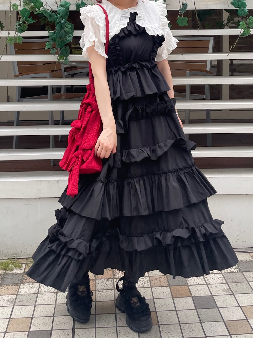 ブラック系のワンピース、ブラック系のサンダル、ホワイト系のシャツ/ブラウスを着用したレディースの夏コーディネートの4枚目の写真