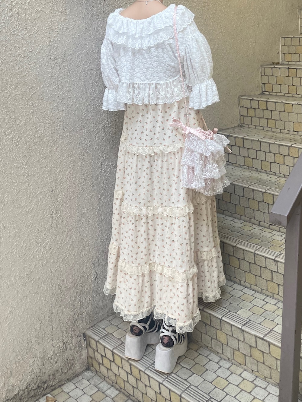 ベージュ系のワンピース、ホワイト系のカーディガン/ボレロ、ピンク系のショルダーバッグを着用したレディースの春コーディネートの4枚目の写真