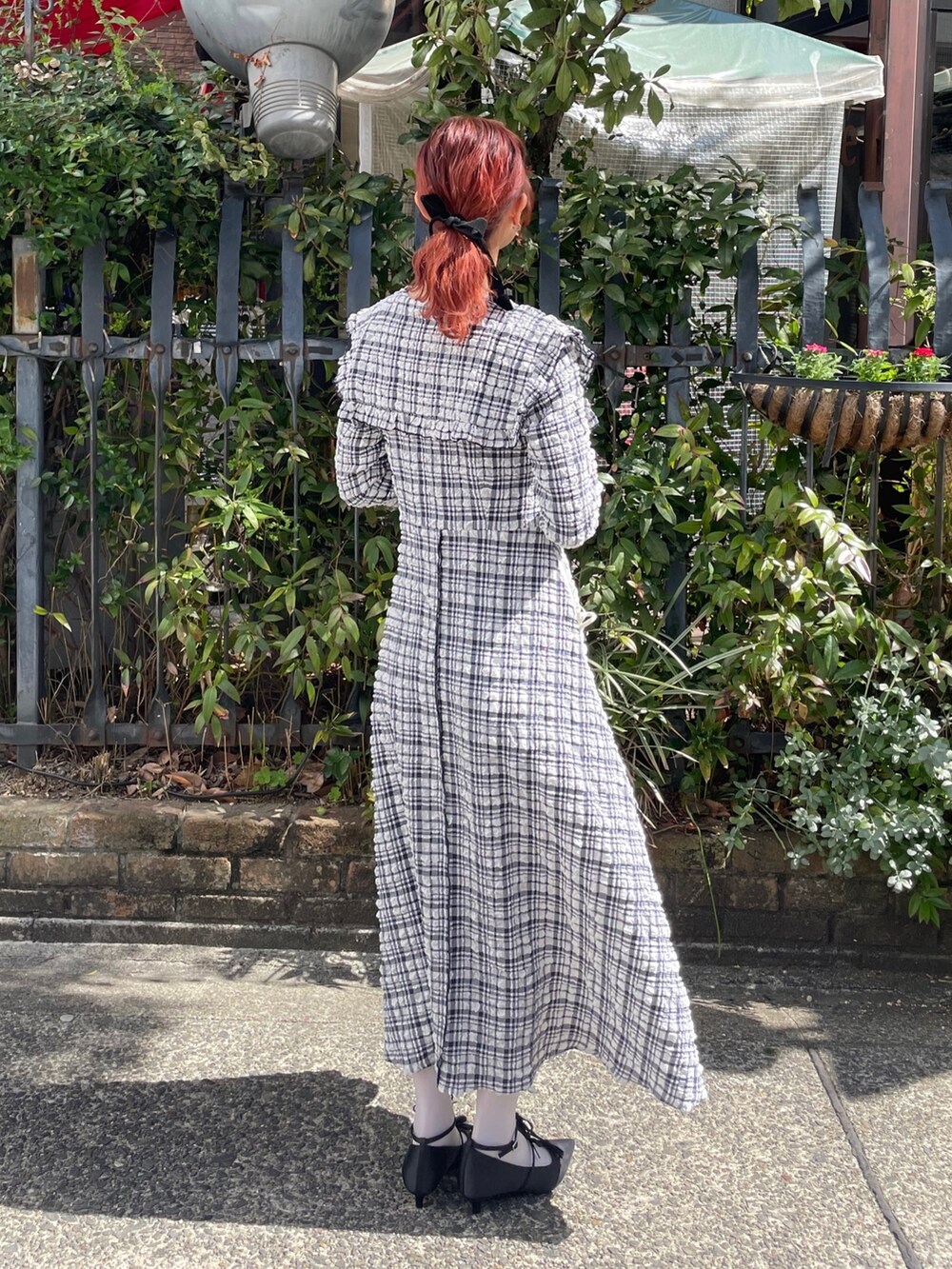 ブルー系のワンピース、ブラック系のパンプスを着用したレディースの春コーディネートの3枚目の写真