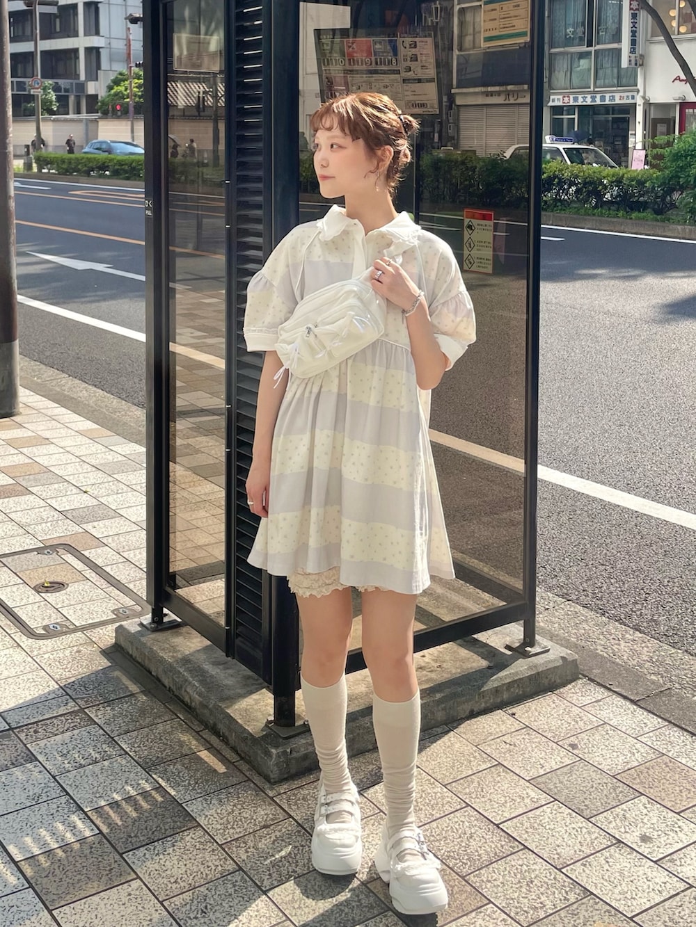 パープル系のワンピース、ホワイト系のスニーカー、ホワイト系のボディバッグ/ウエストポーチを着用したレディースの春コーディネートの2枚目の写真
