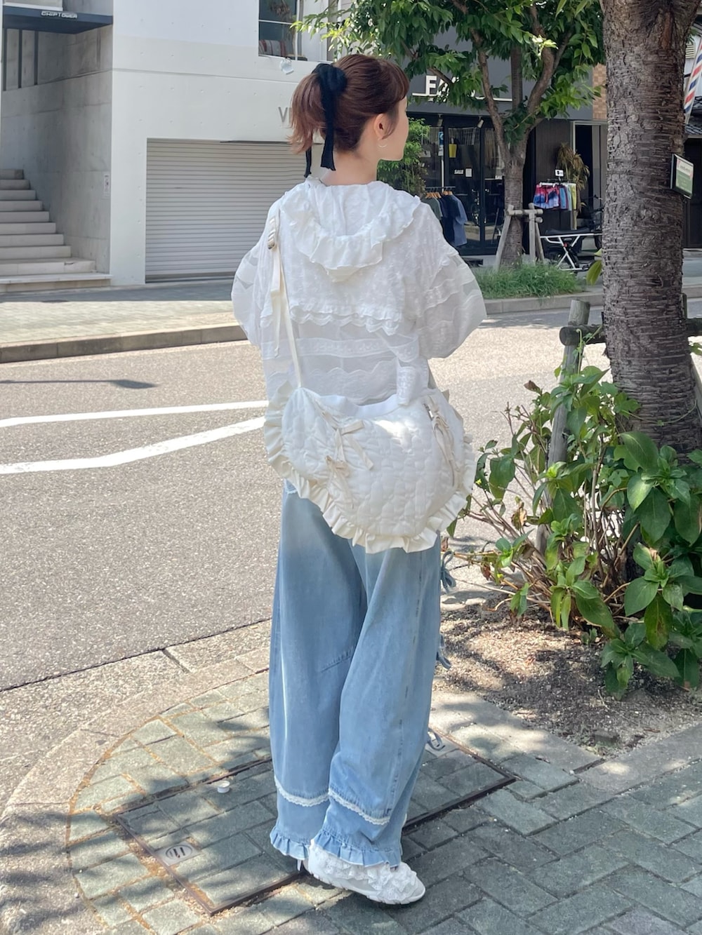 ホワイト系のシャツ/ブラウス、グリーン系のスニーカー、ブルー系のデニムパンツを着用したレディースの夏コーディネートの4枚目の写真