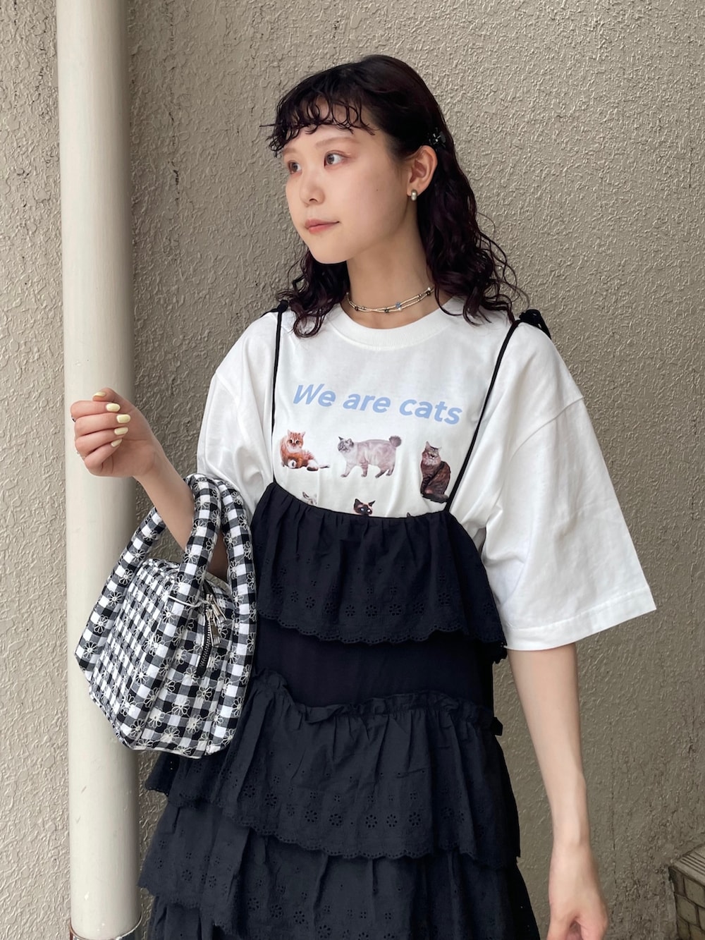 ブラック系のワンピース、ホワイト系のTシャツ/カットソー、ブラック系のサンダルを着用したレディースの夏コーディネートの4枚目の写真