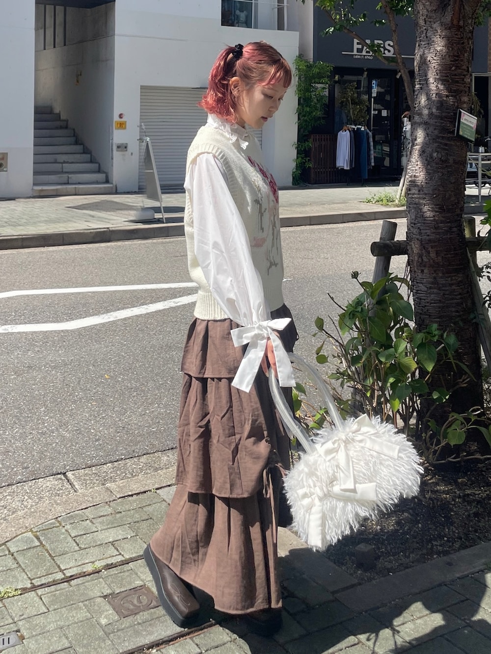 ホワイト系のボストンバッグ、ホワイト系のベスト、ホワイト系のシャツ/ブラウスを着用したレディースの秋コーディネートの3枚目の写真