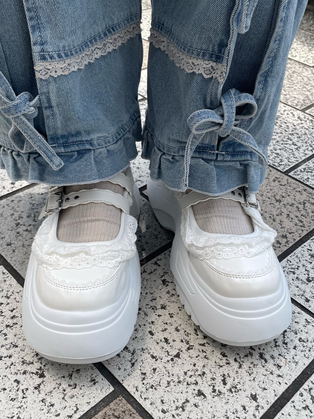 ブルー系のデニムパンツ、ブルー系のショルダーバッグ、ホワイト系のスニーカーを着用したレディースの夏コーディネートの6枚目の写真
